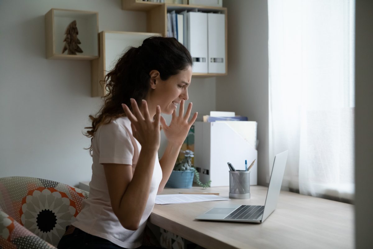 Woman working remotely at home and upset by posting from coworker, for Sexual Harassment Attorney Chicago contact our law firm.